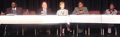 [Photo 4:  Five panelists seating at a long table]