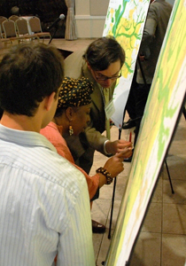 [Photo 2: Planning team members work with a community member to locate an area of interest on the map]