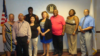 [Photo 1: Pictured from left to right are: Anthony Alfred (front row), Joan Armstrong, Iris- Ann Nguyen (2nd row), Tosha LeSure (back), Sernorma Mitchell, Hubert Collins, Shivona Brownlow, & John Baldwin (3rd row)]