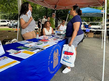 [HUD's Michelle McCarroll (left) and Demetra Daniel describe the Affordable Connectivity Program to a resident of Jackson Tennessee's Allenton Heights community. Many parents were interested in the Program's benefits, especially up to a $100 one-time discount for a laptop, desktop computer or tablet as children will soon be returning to school for the new academic year.]