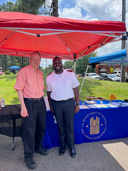 [Walter Perry, Memphis Field Office Director, and Captain Mark Cancia, The Salvation Army, discuss the Affordable Connectivity Program at the 2023 Family Empowerment Expo in the Lincoln Courts Community sponsored by the Jackson Housing Authority in Jackson, Tennessee.]