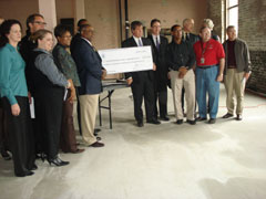 [Photo 2: Continuum of Care members receive the ceremonial check with Mayor Dean assisting]