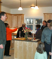 [Photo 2: Guests standing in the kitchen]