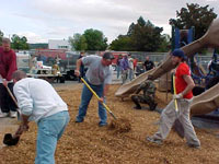 [Photo 1: Volunteers preparing the playground surface]